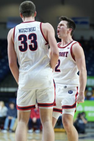 Belmont basketball players Nick Muszynski and Grayson Murphy celebrate the team's win on the court.