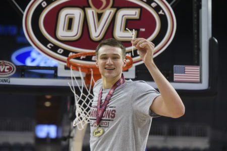 Belmont basketball player Caleb Hollander clips part of net after a win in the OVC championship game.