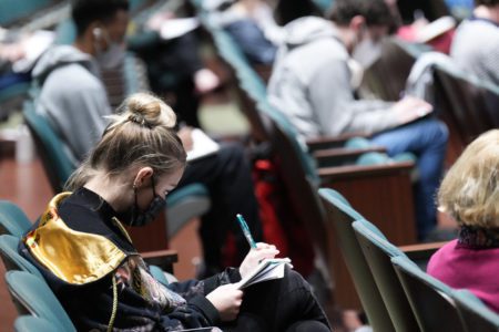 A student takes notes during the developing purpose class.