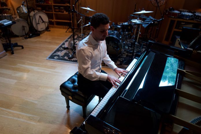 Elliott McClain plays piano in a studio
