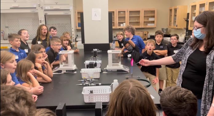 Garrett shows students a science experiment