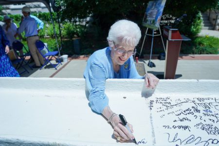 Barbara Massey Rogers signs the final beam