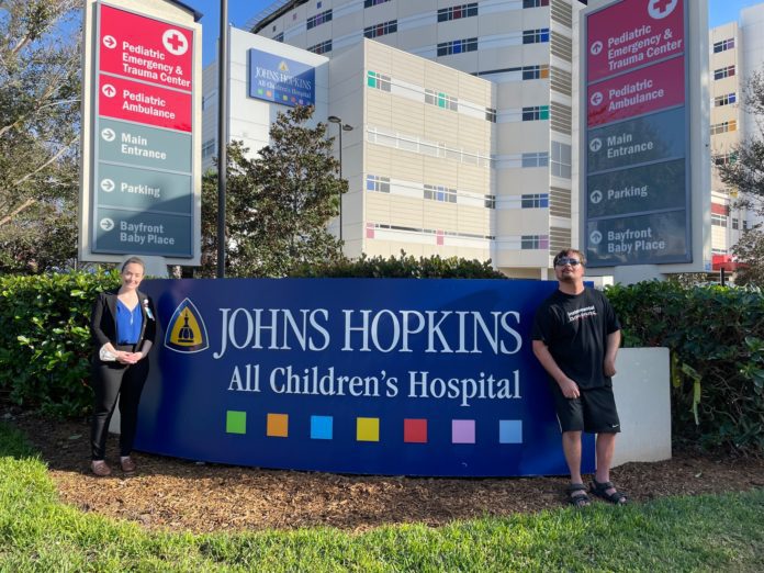 Luke Putney poses in front of Johns Hopkins All Children's Hospital.